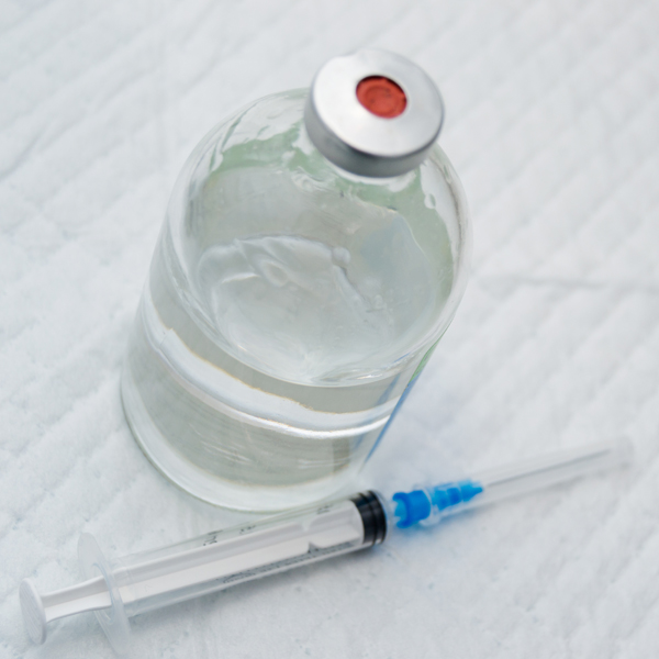 vial with clear drug solution and a syringe