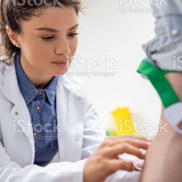 Friendly hospital phlebotomist collecting blood sample from patient in lab. Preparation for blood test by female doctor medical uniform on the table in white bright room